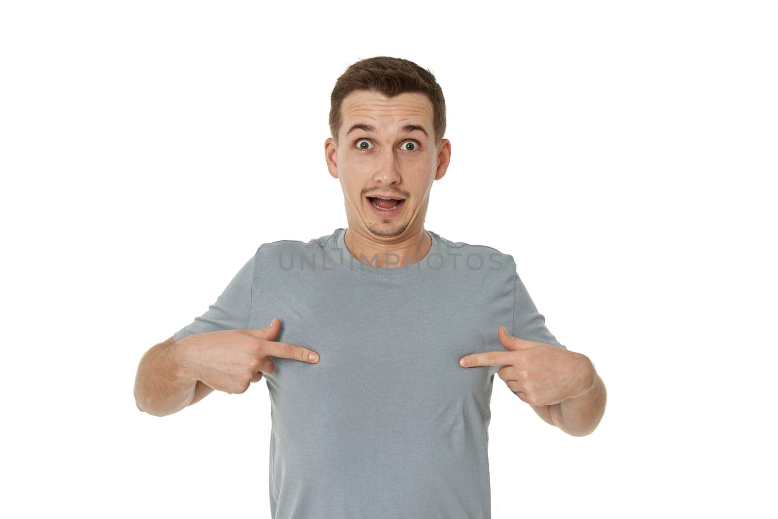 happy guy looking pointing at himself on white studio background