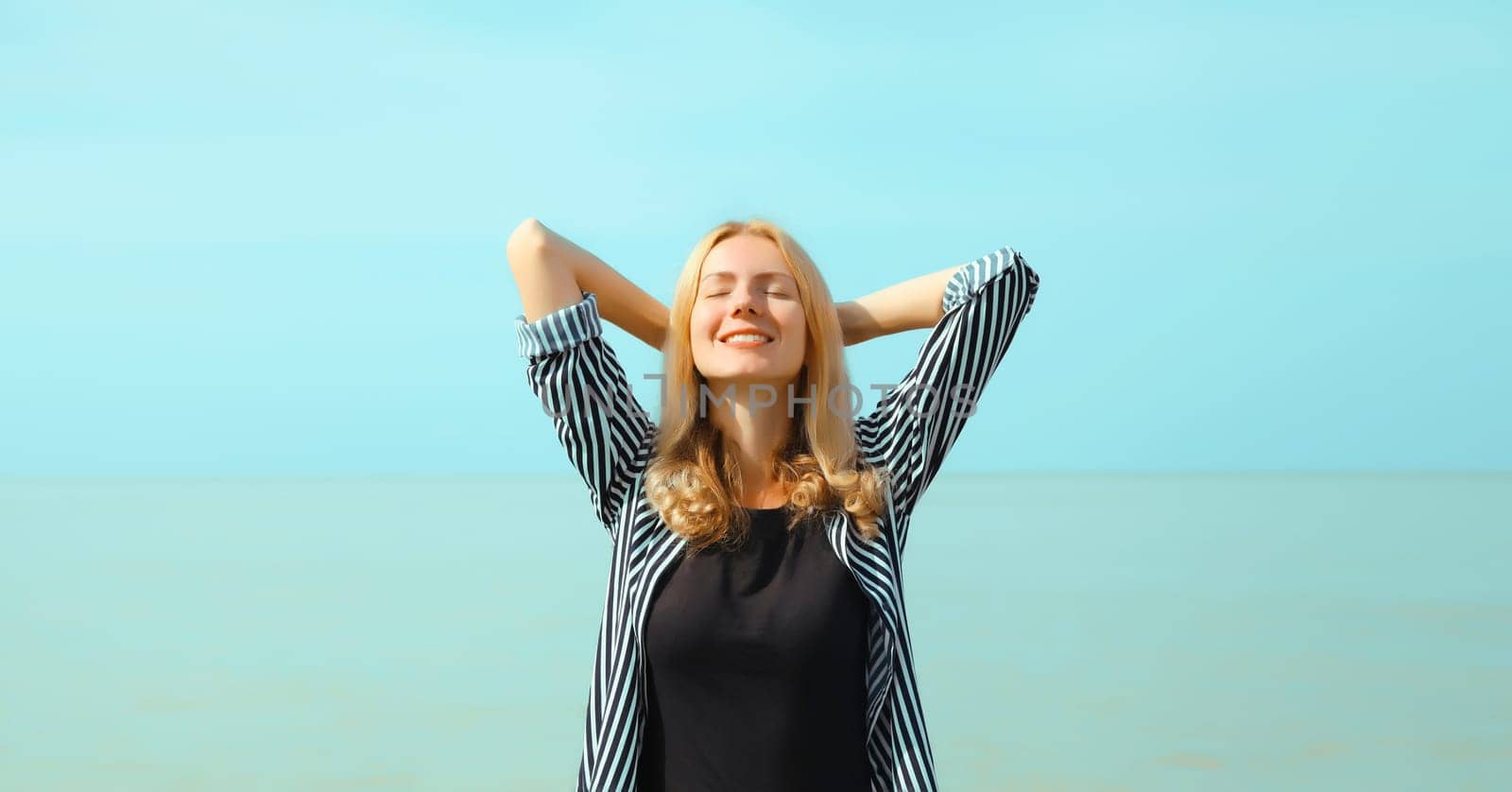 Summer vacation, happy relaxing woman meditates on the beach on sea by Rohappy