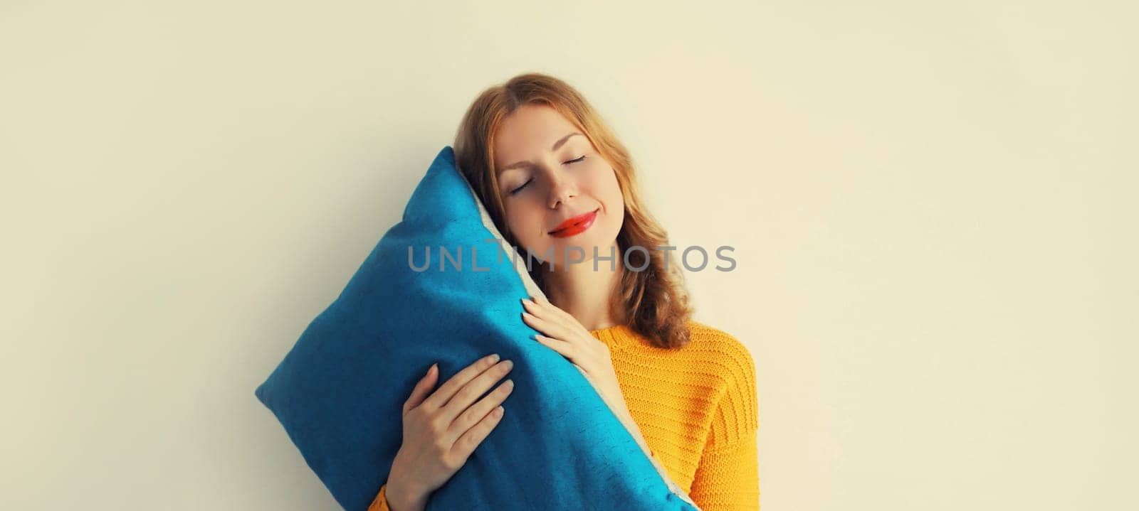 Healthy sleep, happy relaxed sleepy young woman hugs pillow imagining that she is lying on the bed by Rohappy