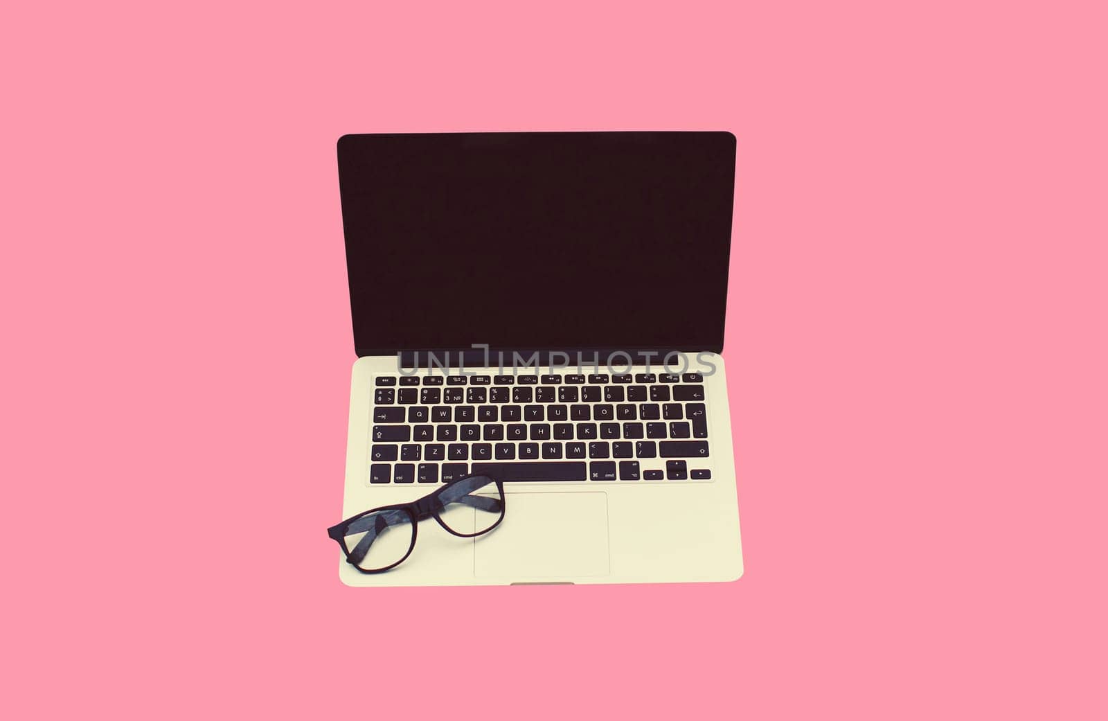 Close up laptop with blank black screen and eyeglasses on pink background by Rohappy