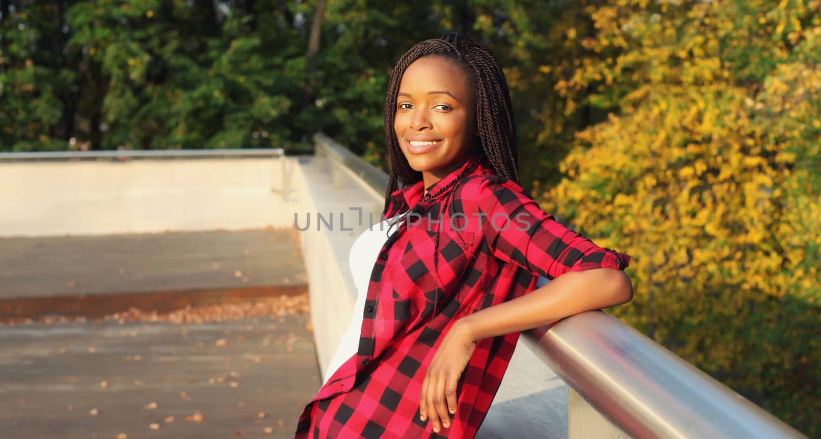 Portrait of stylish young african woman with dreadlocks posing wearing casual in the city