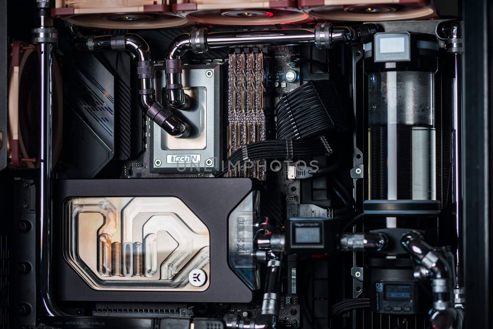 Prague, Czech Republic - 21 July 2021: Close-up of high performance Desktop PC and water cooling system with multicolored LED RGB light show status on working, interior on Computer PC Case and DIY