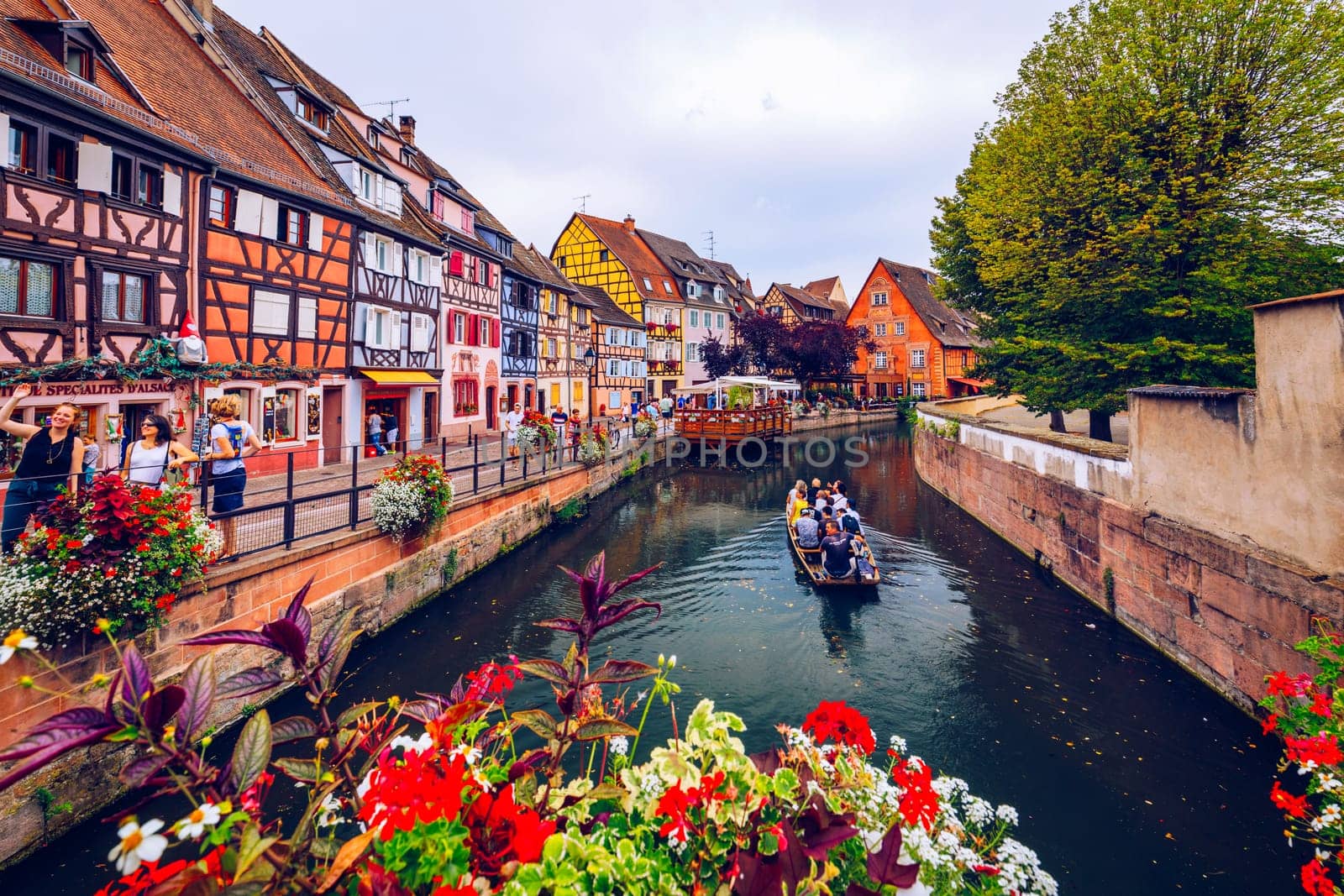 Colmar, France - July 27, 2018: Old town of Colmar, Alsace, France. View with colorful buildings, canal and flowers. Colmar, France. Petite Venice, water canal and traditional half timbered houses.
