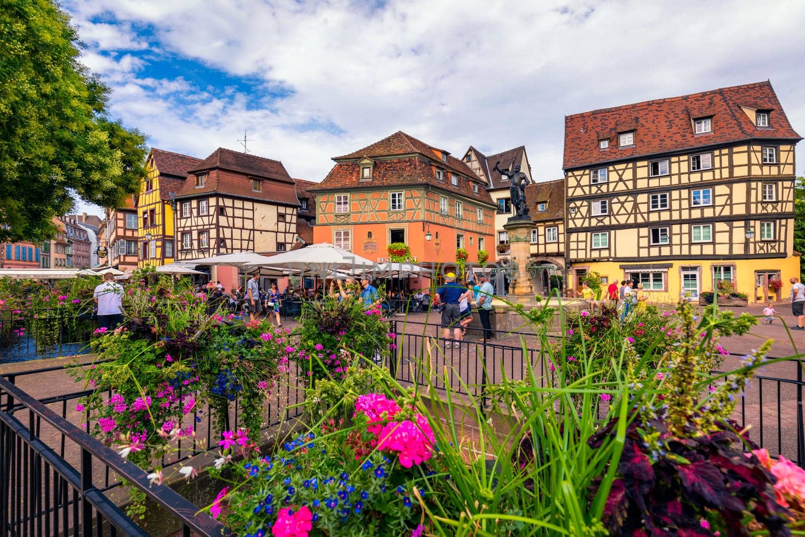 Colmar, France - July 27, 2018: Old town of Colmar, Alsace, France. View with colorful buildings, canal and flowers. Colmar, France. Petite Venice, water canal and traditional half timbered houses.