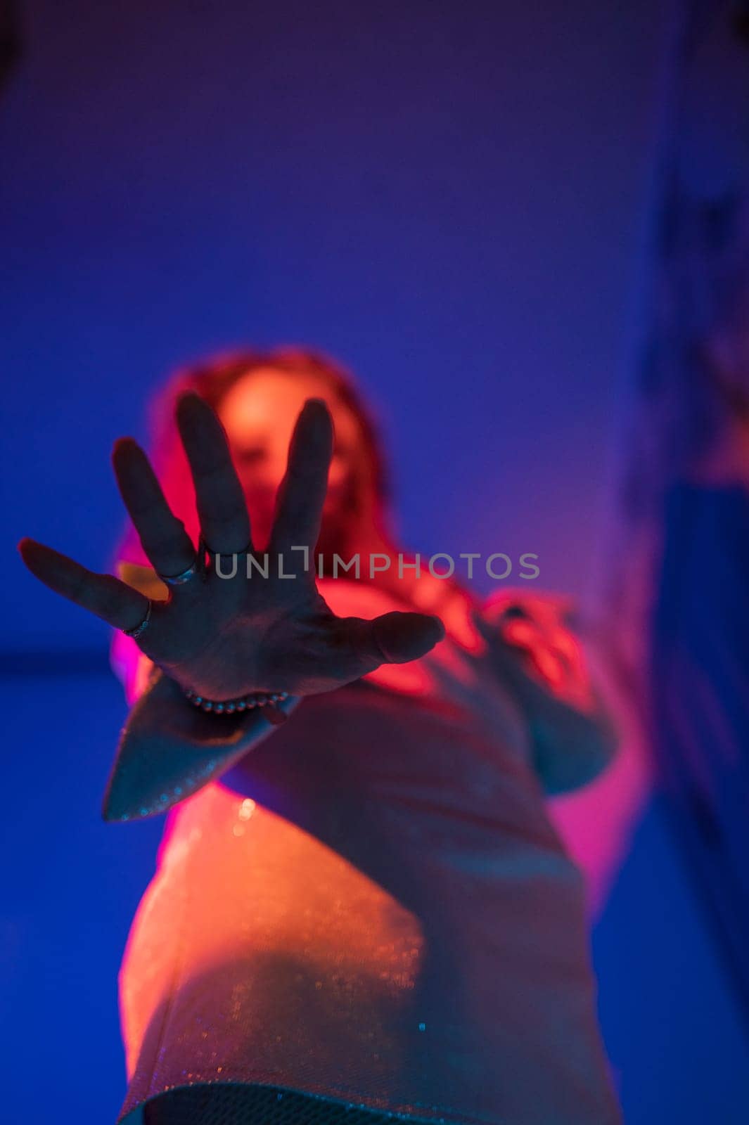 Woman hand closeup with neon color background