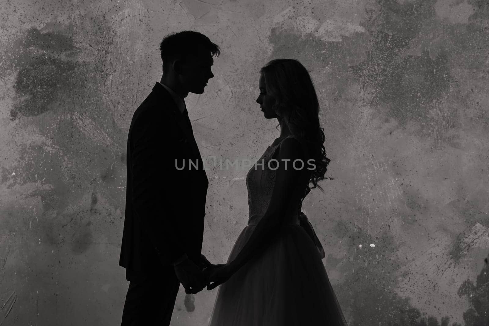 Art fashion studio photo of wedding couple silhouette groom and bride on colors background. Art Wedding style.