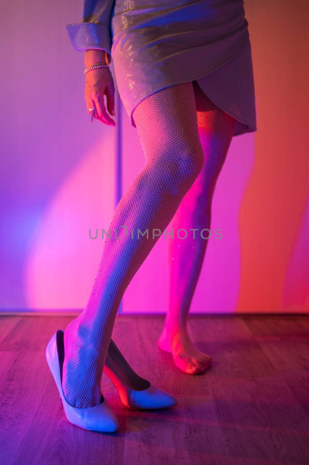 Woman legs closeup in stokings with neon color background
