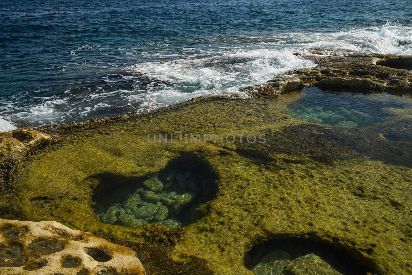 saint peter pools Malta rock formation hole on rocks by AndreaIzzotti