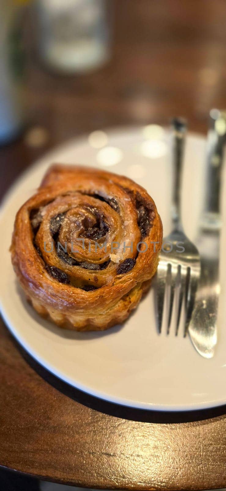 delicious freshly baked Cinnamon rolls or cinnamon bun, with raisins and vanilla also icing sugar ridiculously good pastry