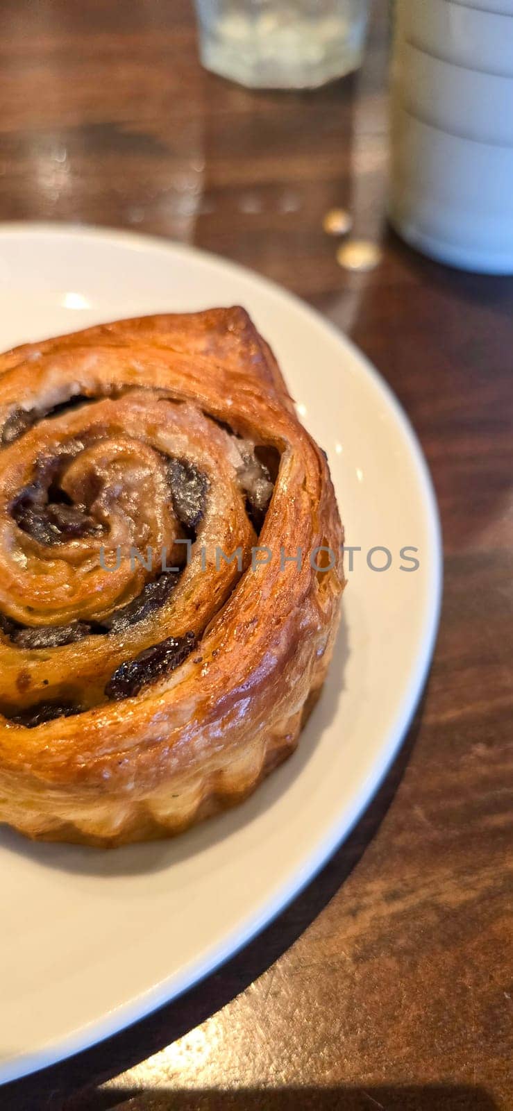 delicious freshly baked Cinnamon rolls or cinnamon bun, with raisins and vanilla also icing sugar ridiculously good pastry