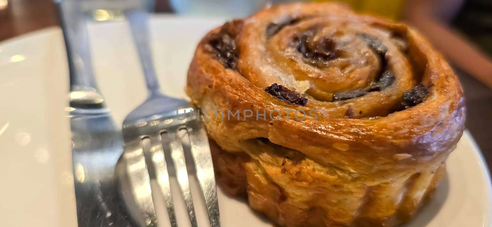 delicious freshly baked Cinnamon rolls or cinnamon bun, with raisins and vanilla also icing sugar ridiculously good pastry
