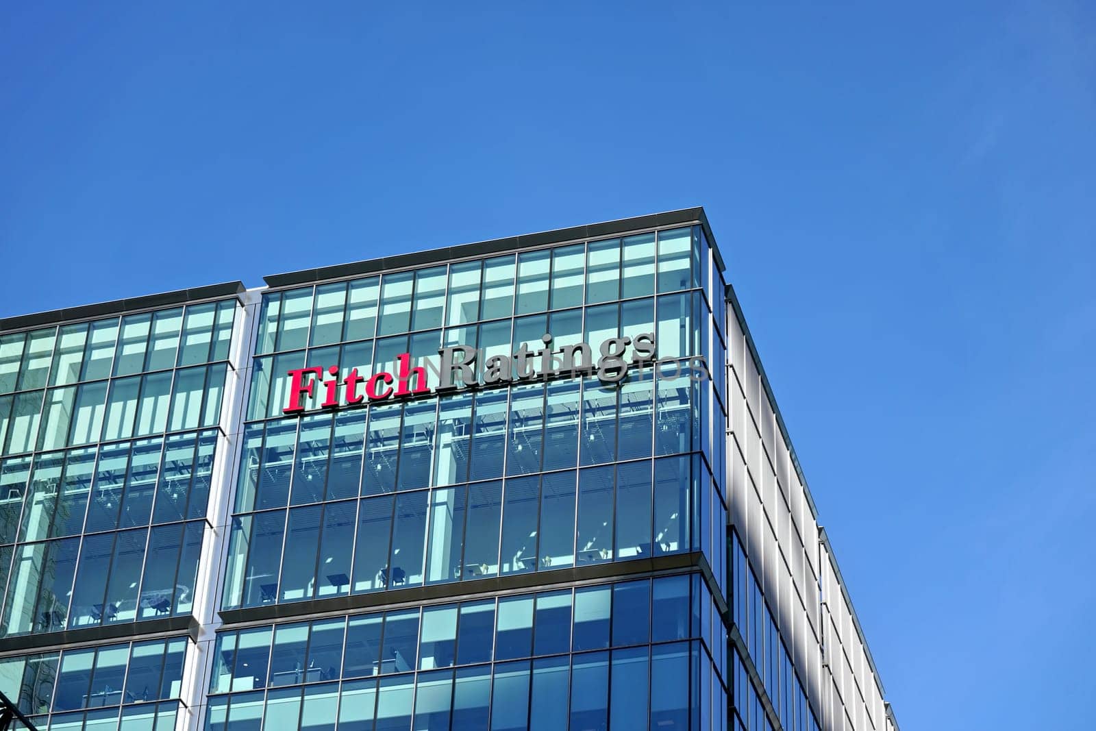 London, United Kingdom - February 03, 2019: Fitch Ratings logo signage at top of their Headquarters in UK (other is in New York), Canary Wharf. FR is one of the Big Three credit rating agencies by Ivanko