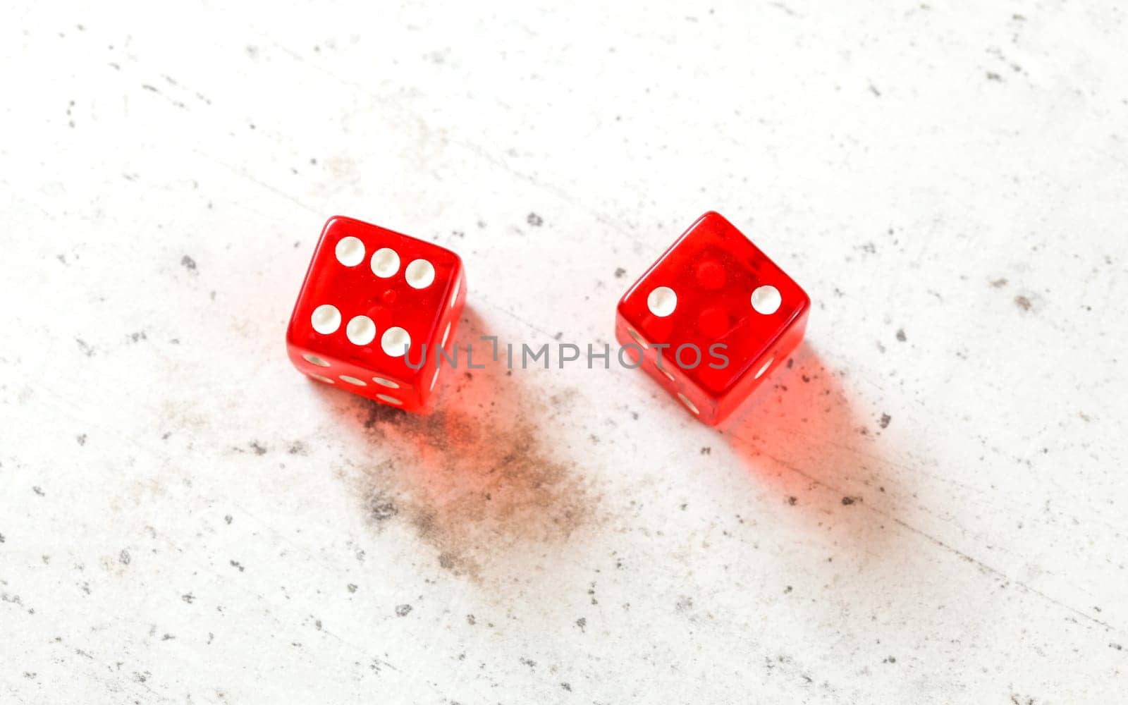 Two red craps dices showing Easy Eight (number 6 and 2) overhead shot on white board