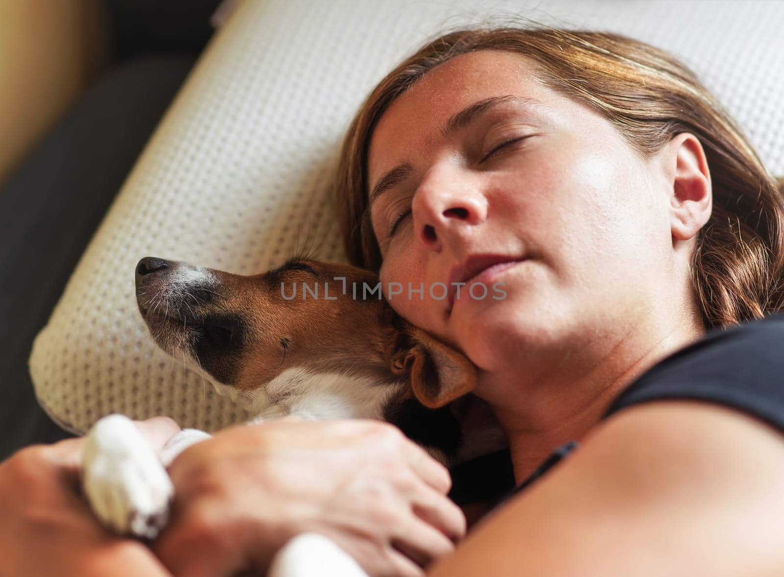 Young woman sleep with small dog, hugging her near, detail on heads and pillow