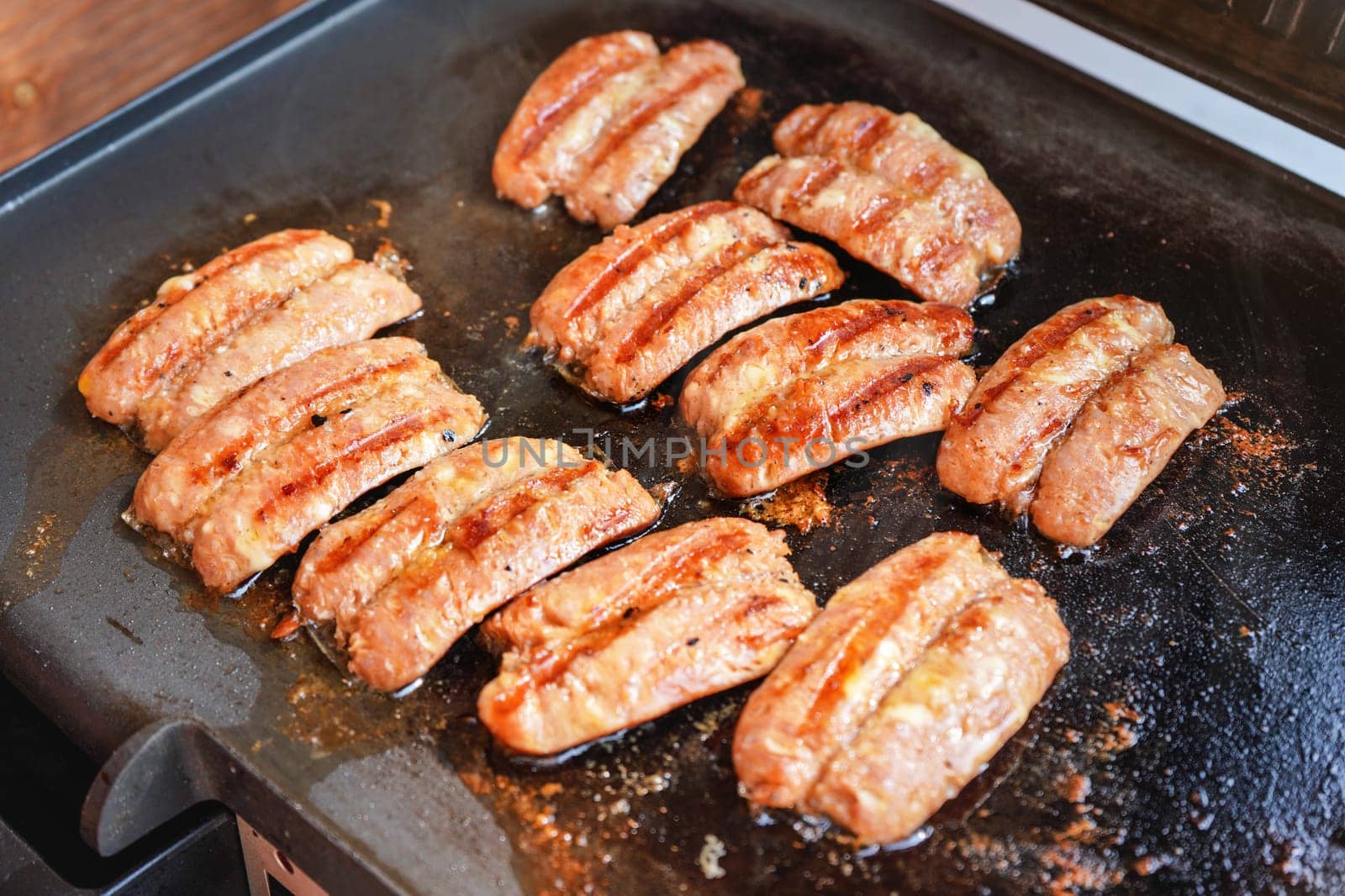 Small bratwurst / hot dog frankfurter sausages grilled on electric grill