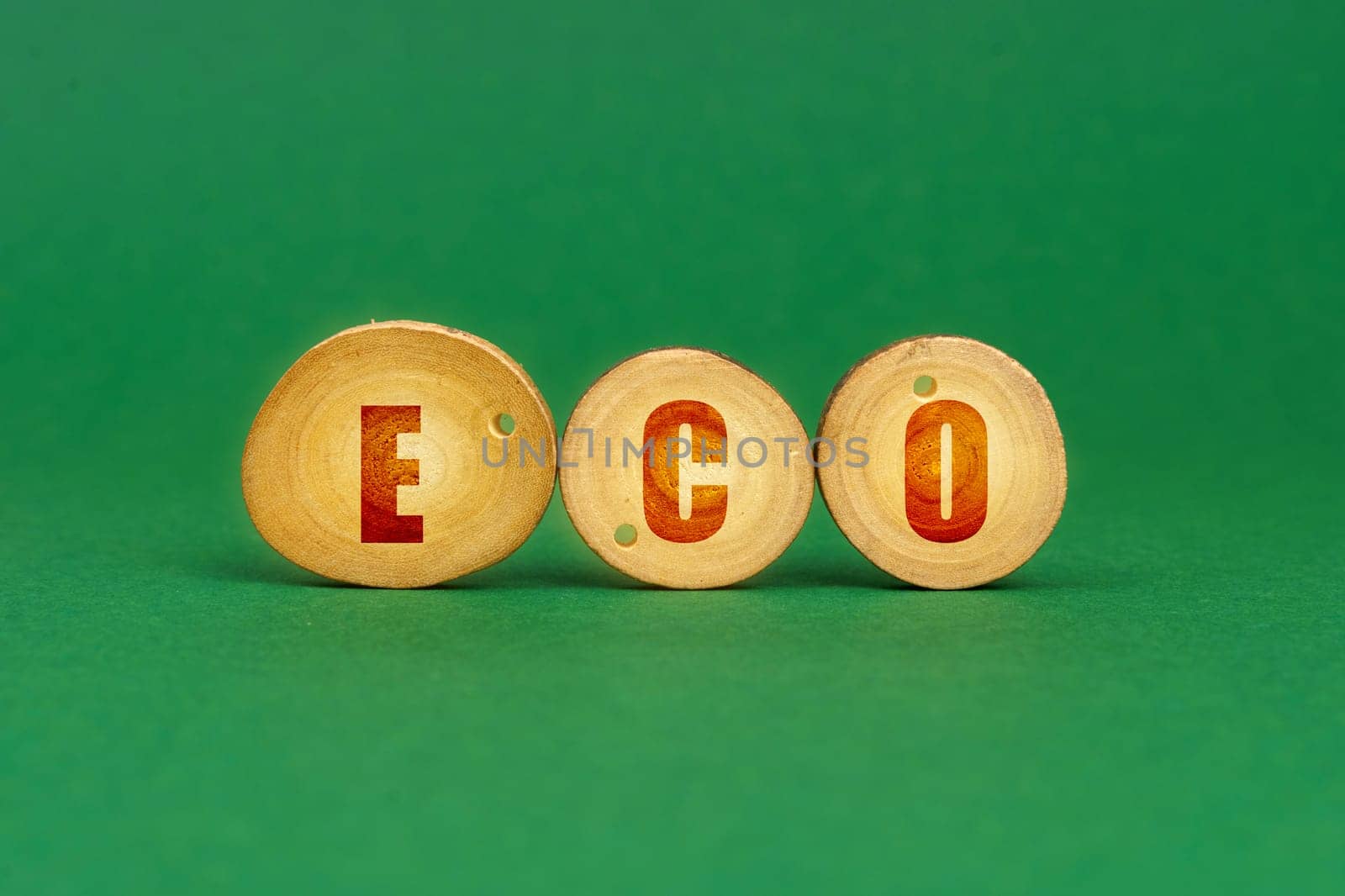 Ecological concept. On a green background, wooden roundels with the inscription - ECO