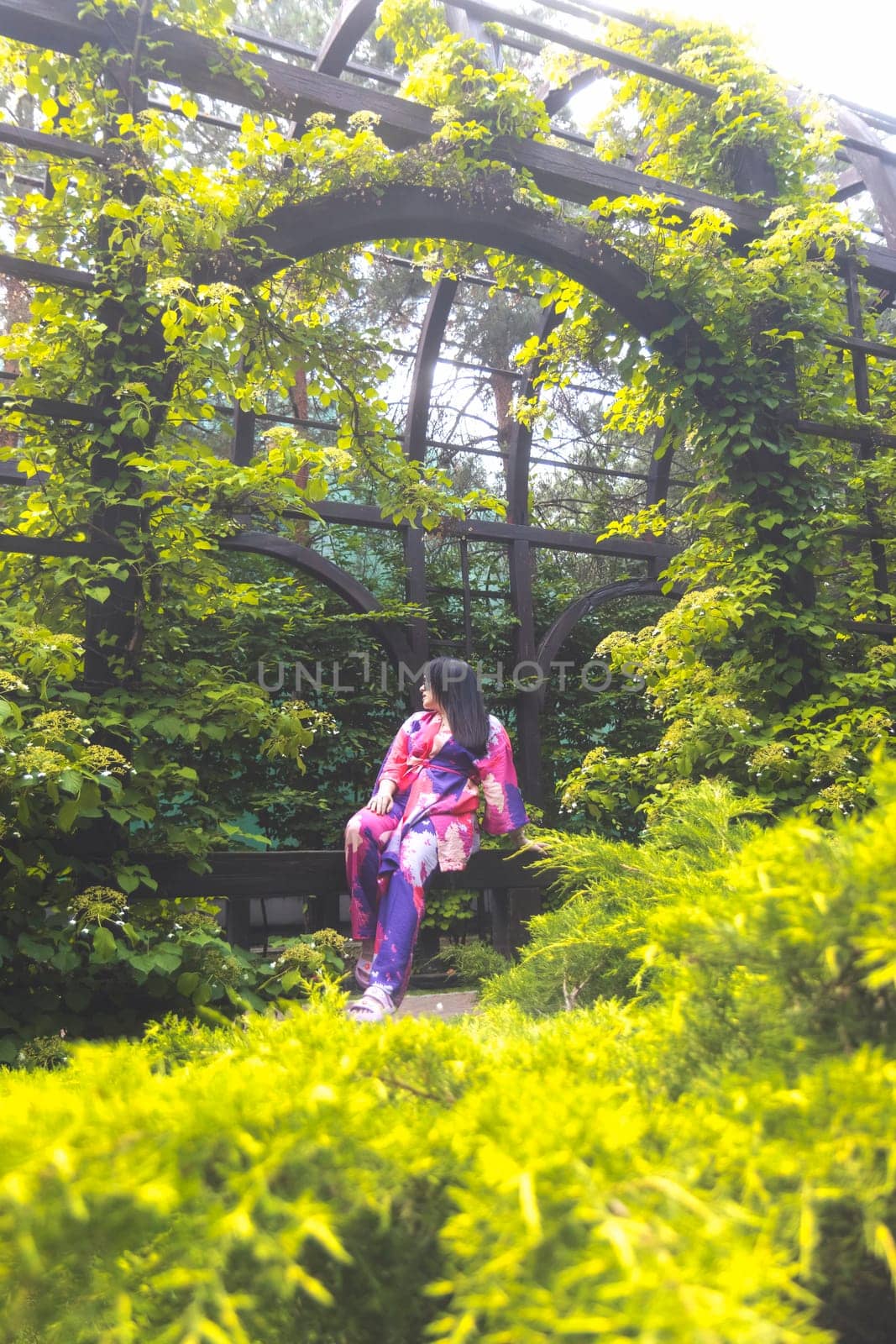 girl in a colored kimono among green thickets , spring walk