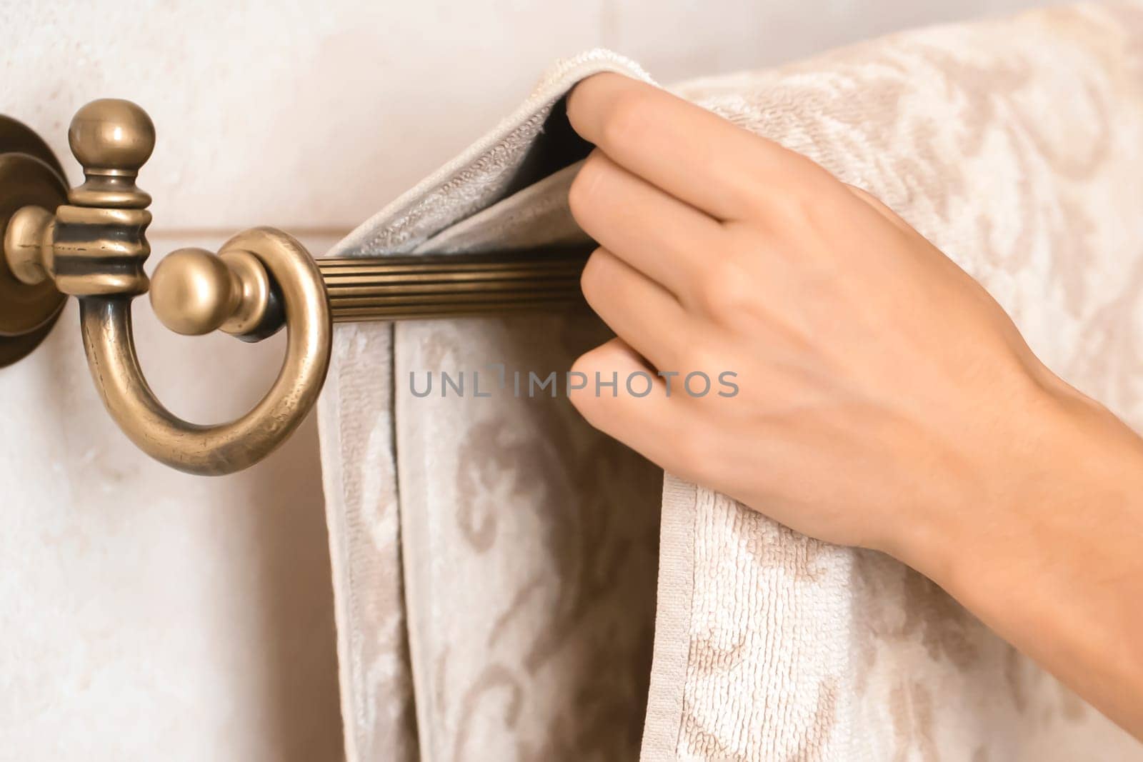 Girl is hanging clean towel on a holder. by africapink