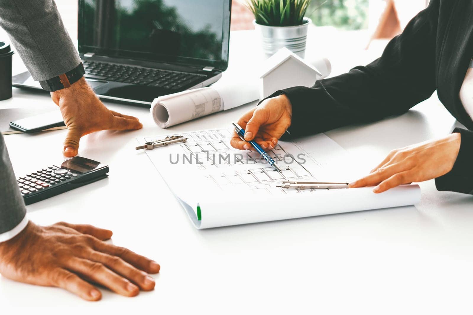 Architect and engineer working with construction drawing project on table in office. Architecture and engineering business concept. uds