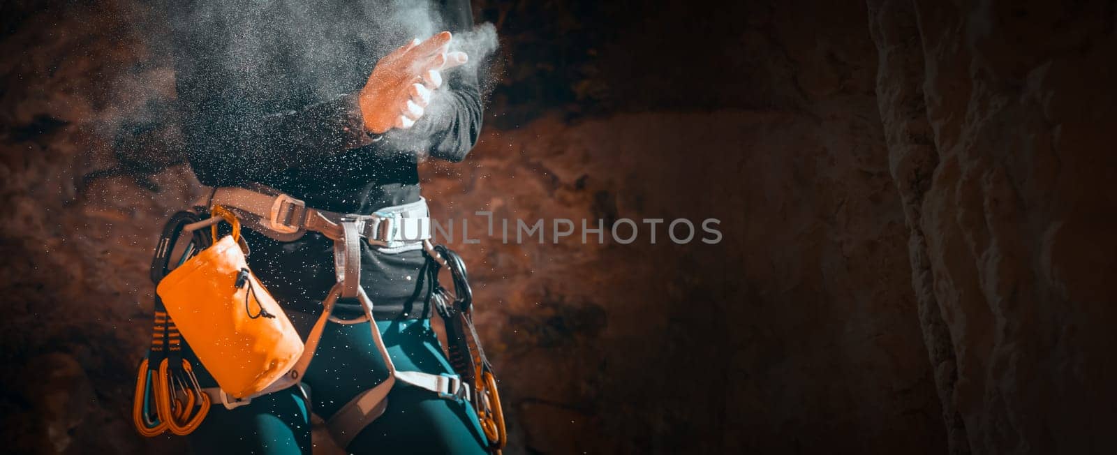 The girl is engaged in rock climbing, uses white powder of magnesia, claps her hands close-up, the woman leads an active lifestyle, climbs the mountains outdoor.