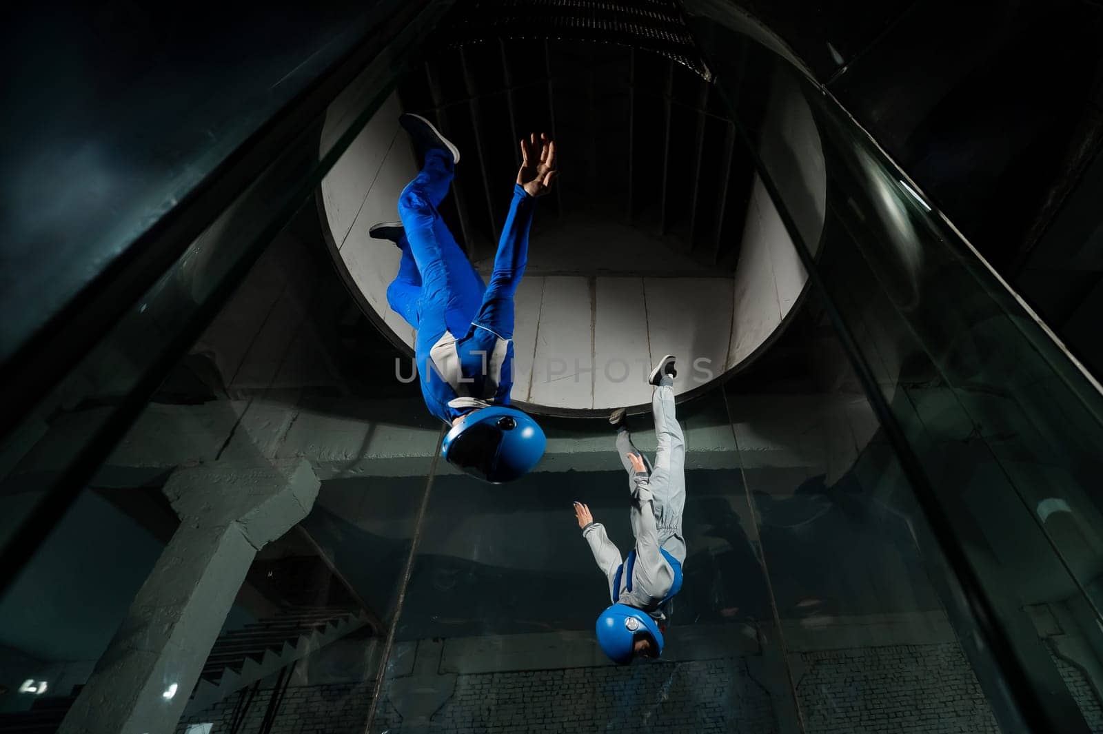 A man and a woman enjoy flying together in a wind tunnel. Free fall simulator.