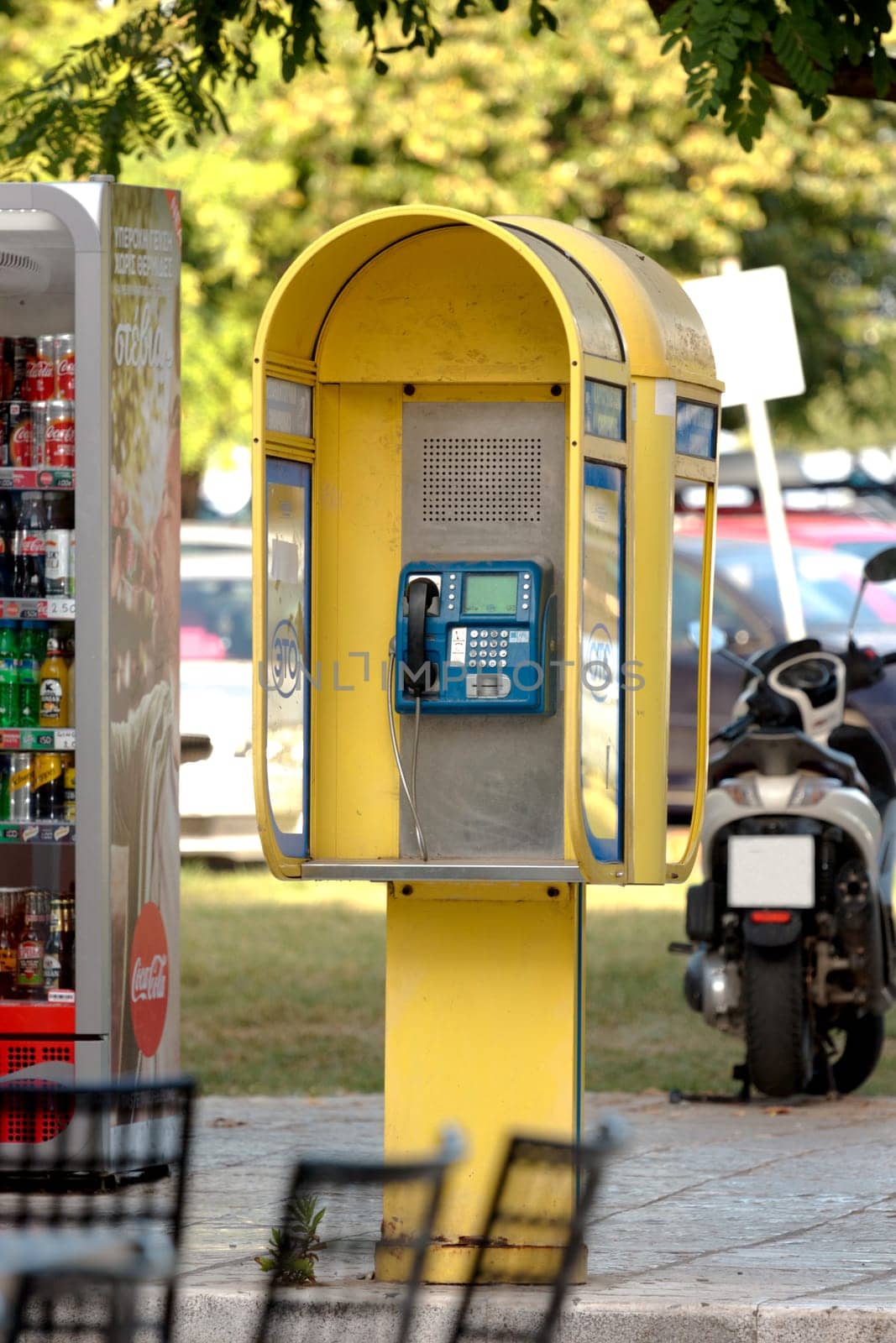 Old yellow OTE telephone booth in the center, OTE is the Hellenic Telecommunications Organization by mailos