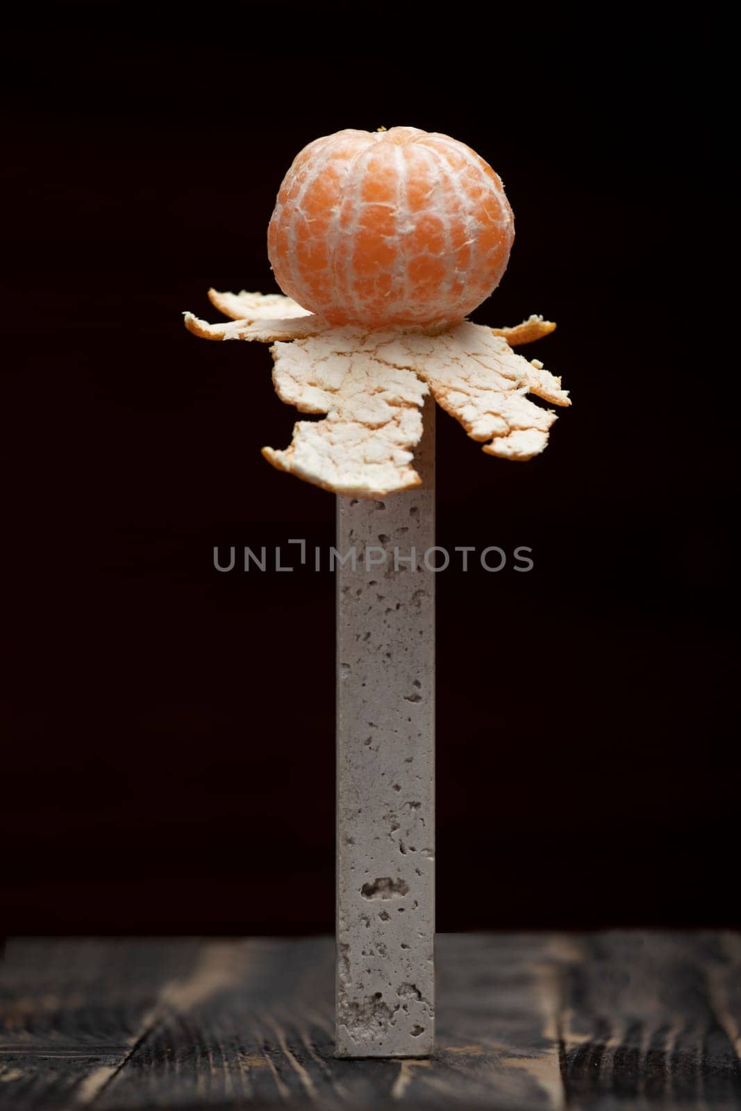 One peeled tangerine isolated with space on a black background