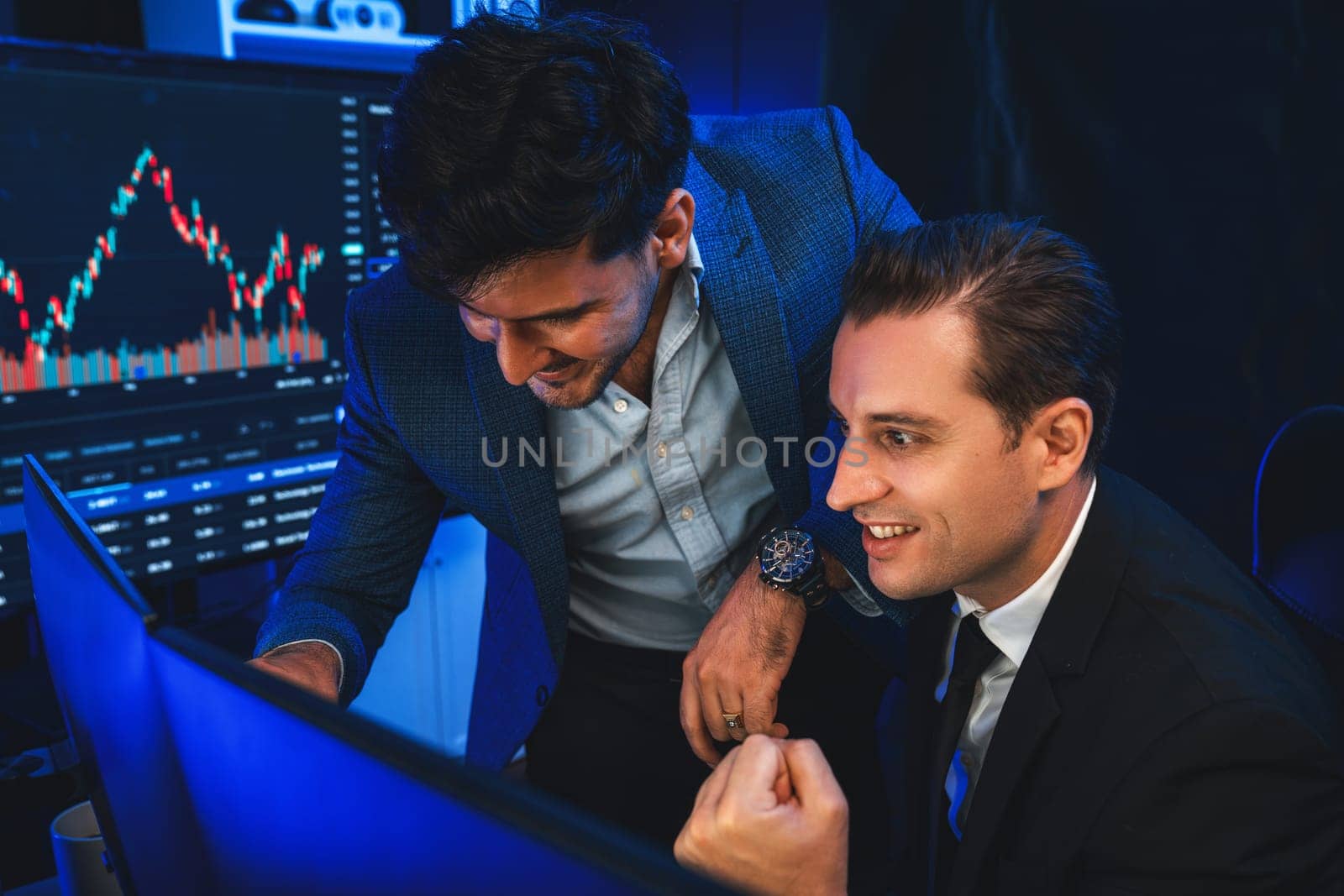 Successful two stock exchange traders raising fist up for digital currency achievement focusing on dynamic data background. Business partners earning high profit analyzed by market graph. Sellable.