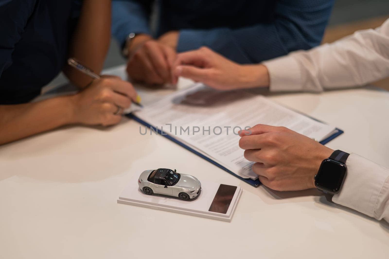 Close-up of the couple's hands signing a contract to buy a car salon. by mrwed54