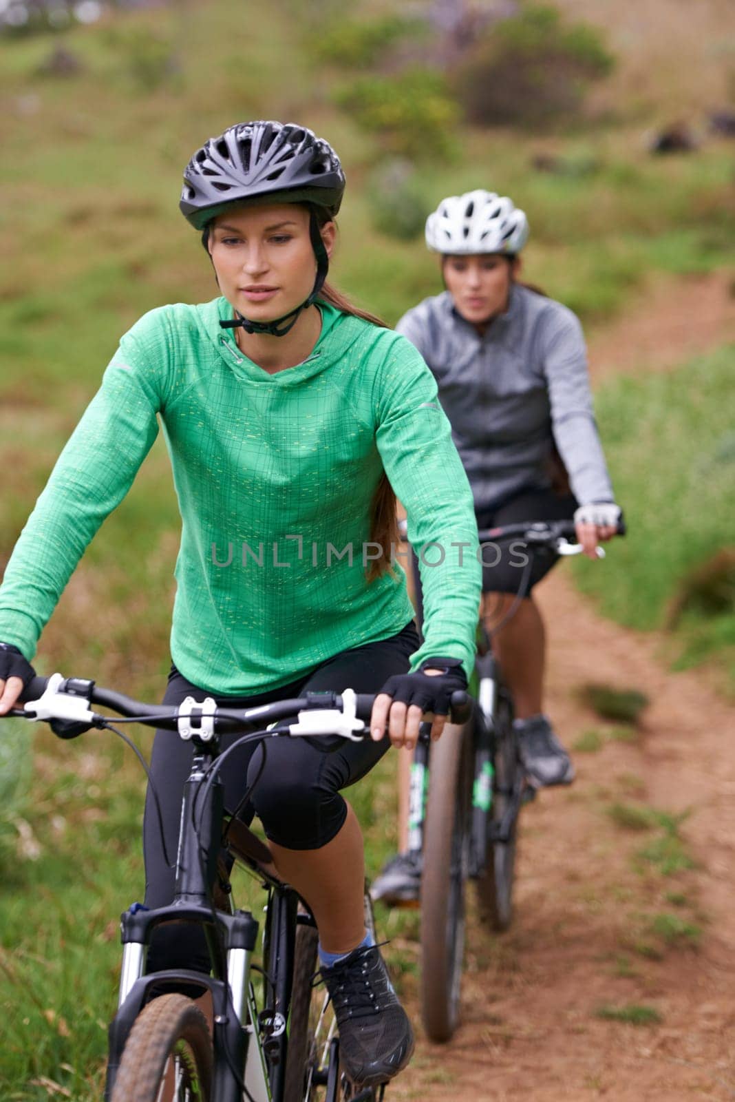 Woman, friends and cycling in nature on bicycle for fitness, cycling or off road travel on trail or path. Female person, biker or cyclist in forest for outdoor workout, training or sports exercise by YuriArcurs
