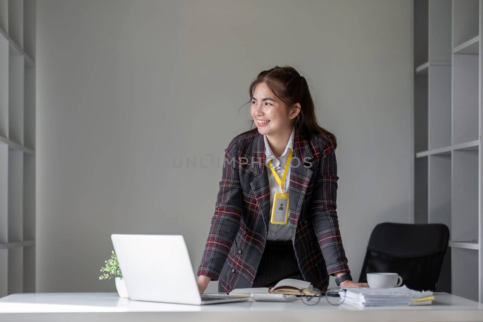 Portrait of a successful business woman Smiling happily at the desk. by wichayada
