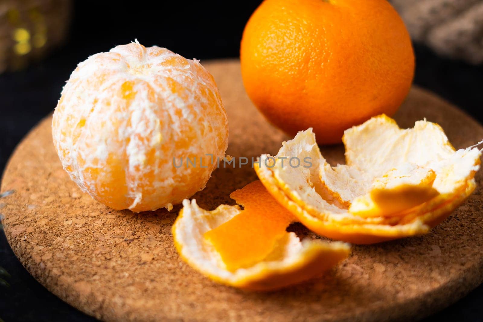 Tangerines and apples in a baskets and peeled tangerine slices on the table.