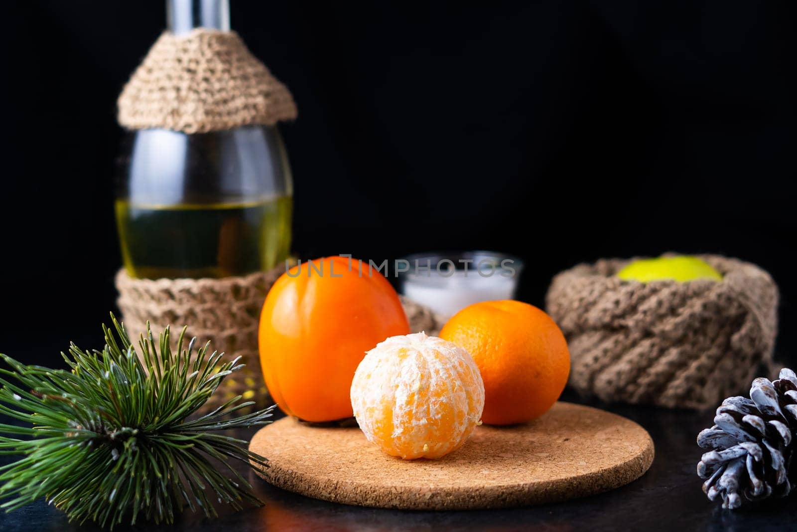 Tangerines and apples in a baskets and peeled tangerine slices on the table.