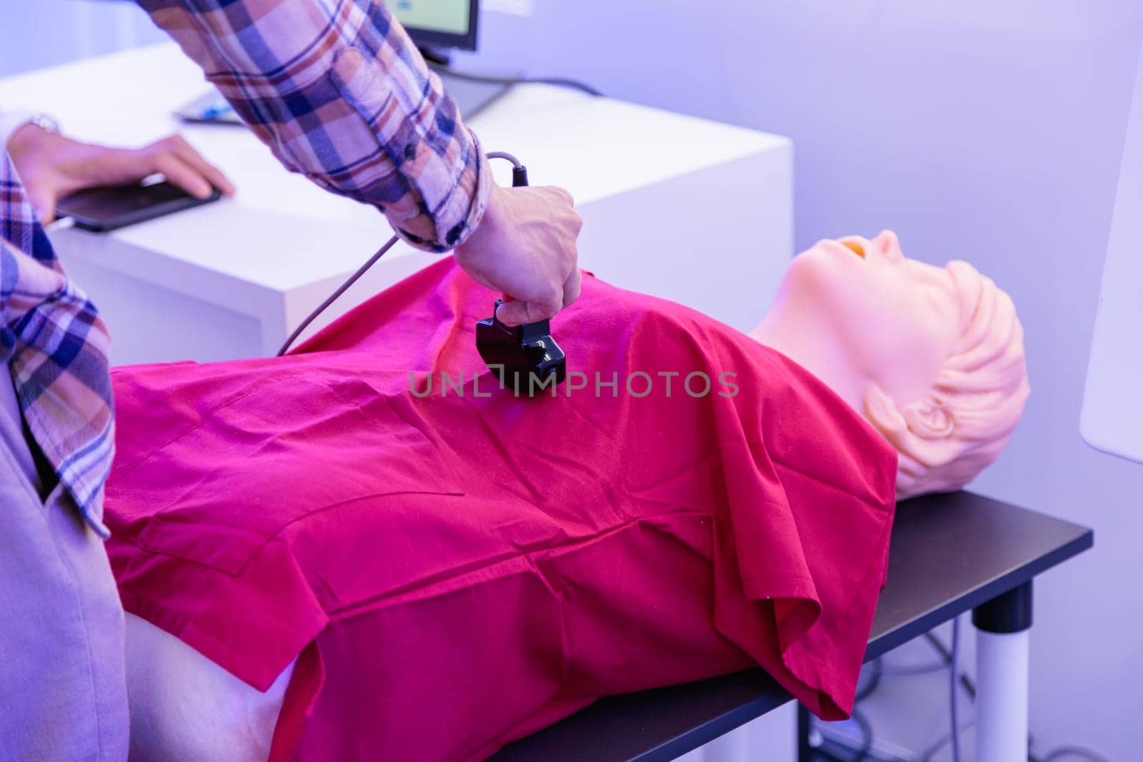 A man tries ultrasound on a mannequin at a health care expo. High quality photo