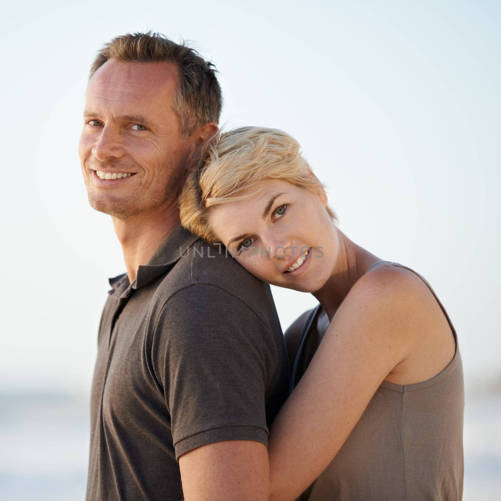 Couple, hug and portrait on beach or holiday relax in California for marriage vacation, together or summer. Man, woman and face for date in paradise for stress relief or outdoor, calm or relationship.