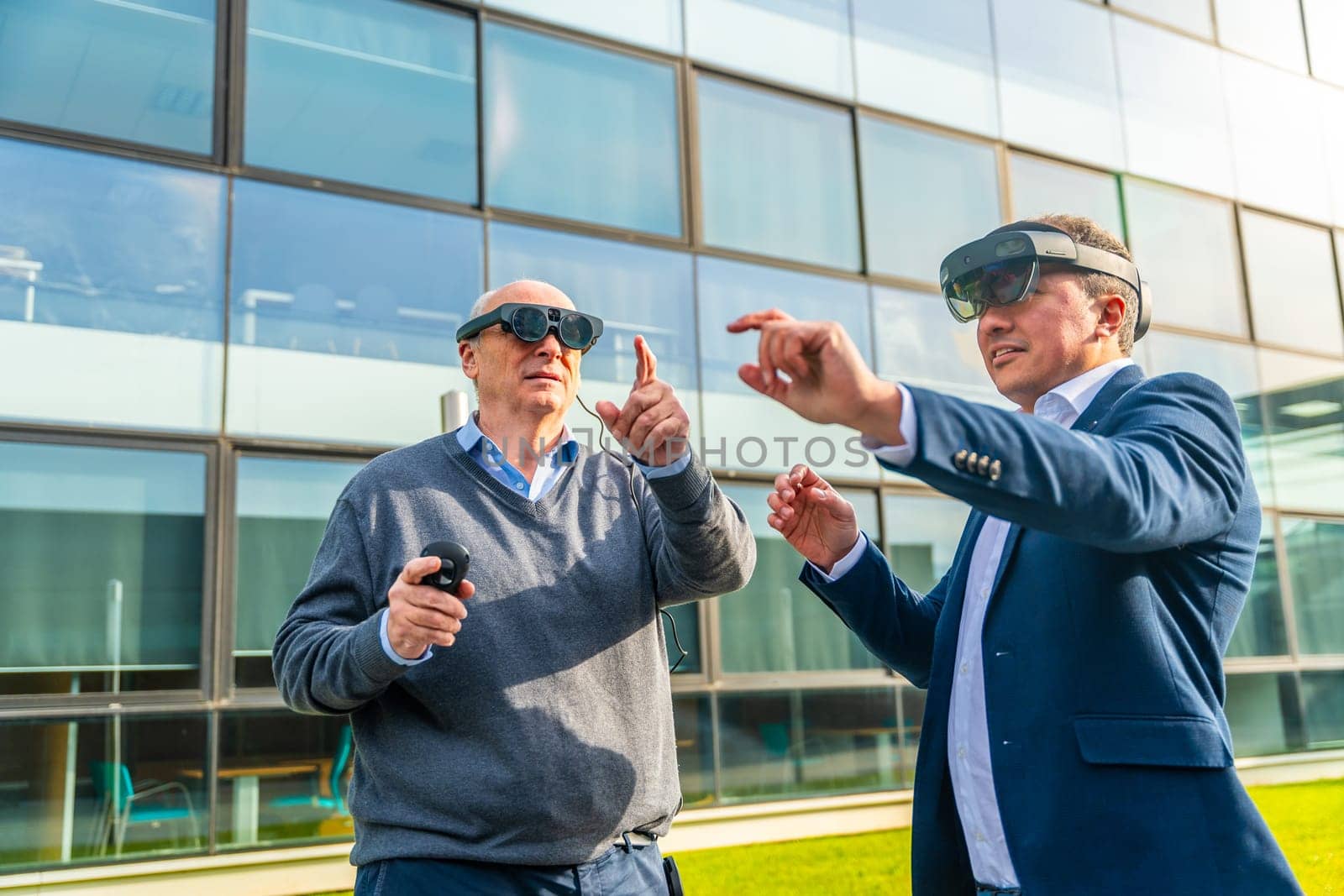 Businessman with colleague wearing virtual reality simulator gesturing by Huizi