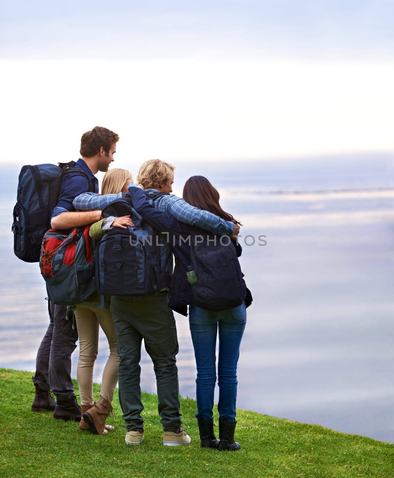 Friends, people hug with back and hiking on mountain, travel with view of horizon outdoor, ocean and backpacking in Europe. Support, trust and friendship, trekking for adventure and looking at nature.