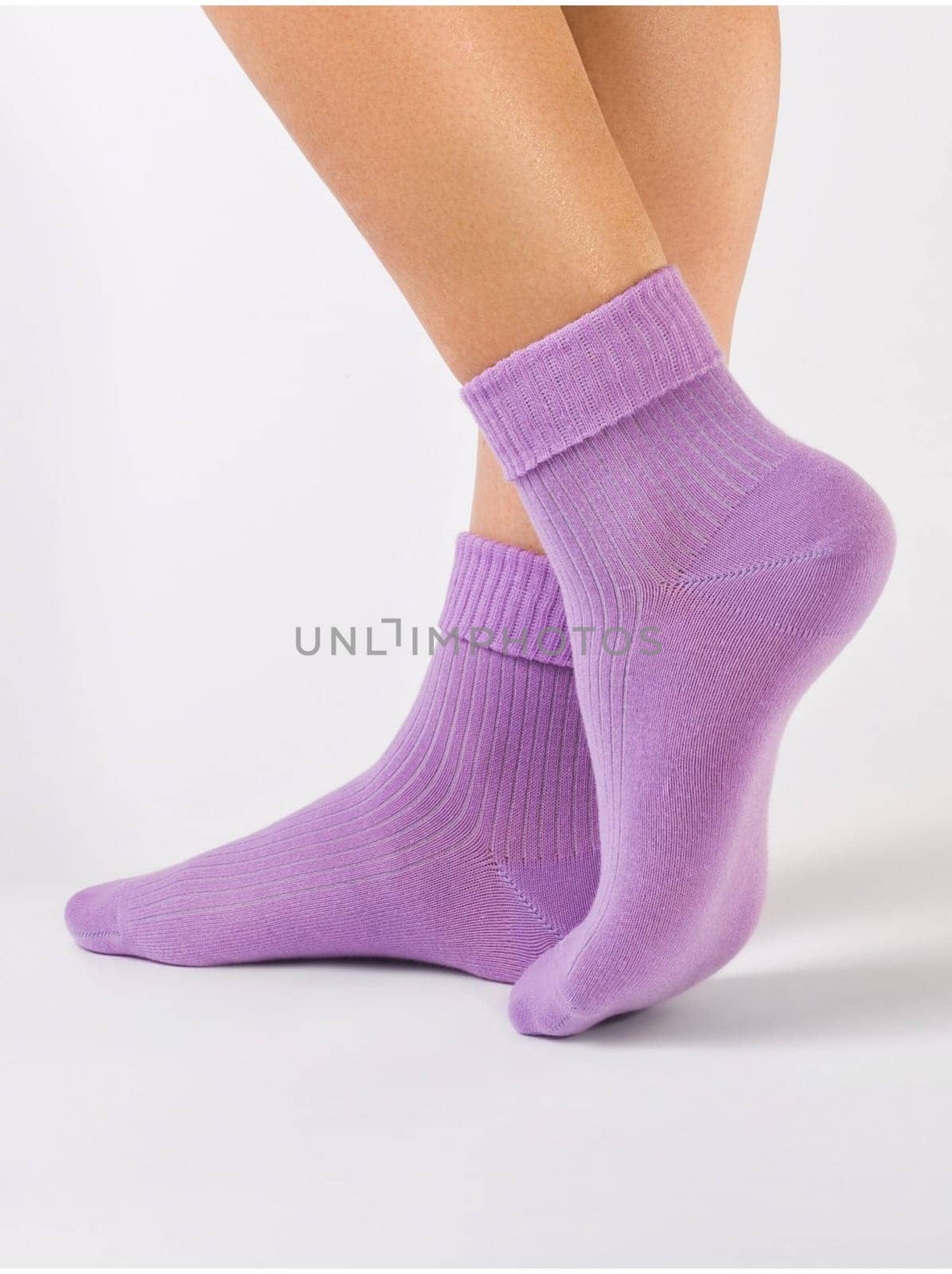 Side view of beautiful woman foot dressed in new nice and soft natural cotton fabric blank purple socks by BY-_-BY