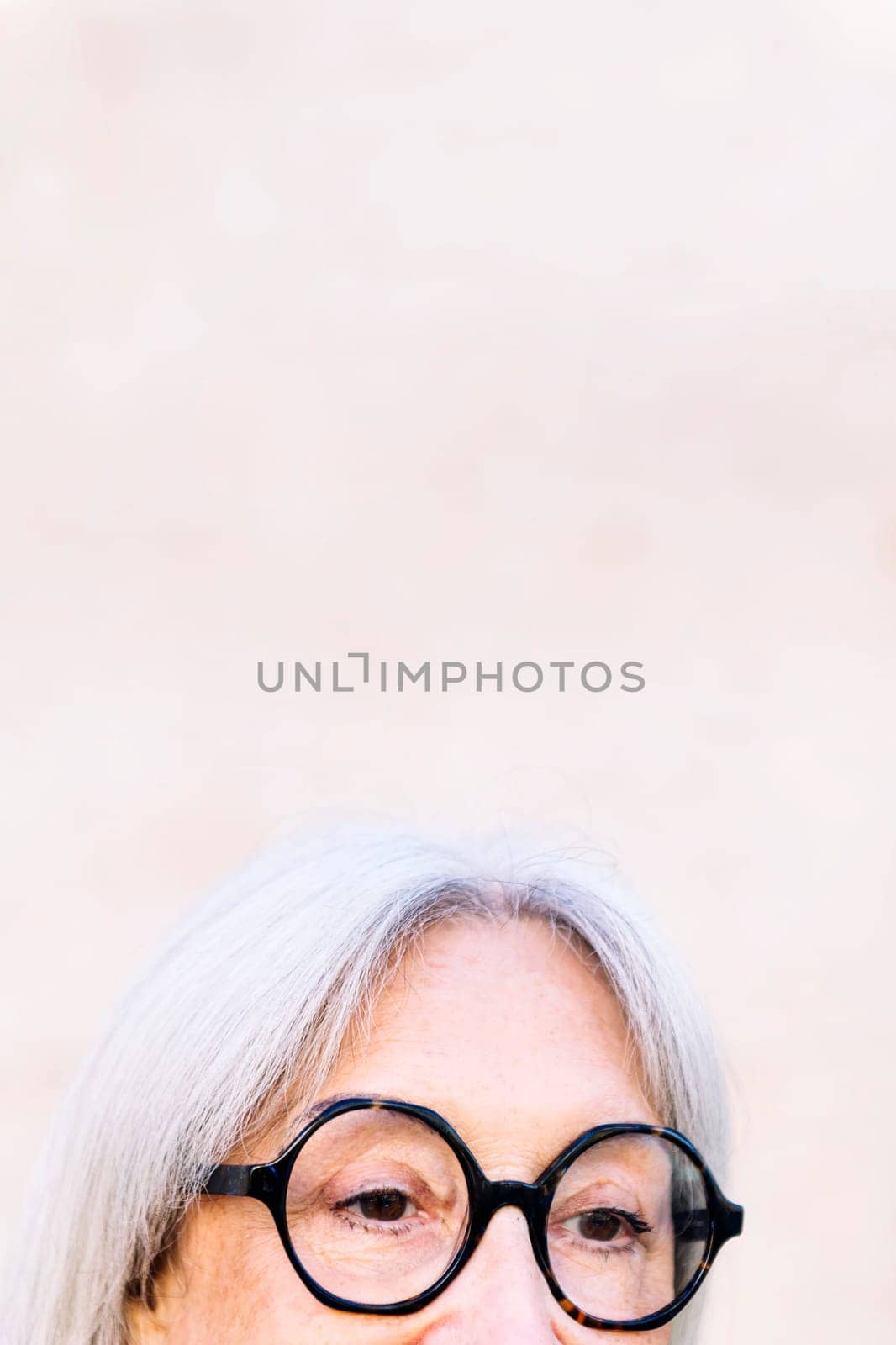 detail of the eyes of an unrecognizable senior woman with glasses, concept of happiness of elderly people and active lifestyle, copy space for text