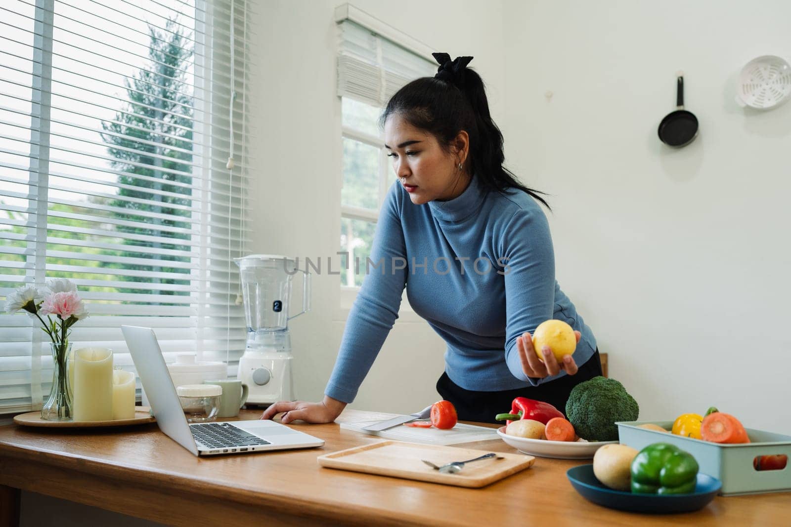 overweight Asian woman learning to make salad and healthy food from social media.