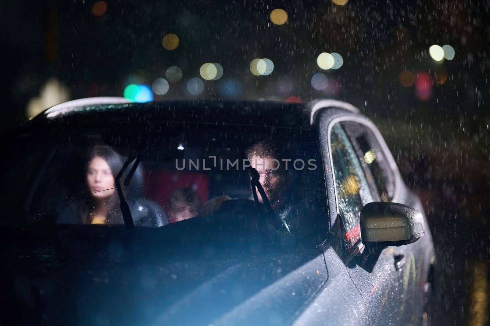 In the midst of a nighttime journey, a happy family enjoys playful moments inside a car as they travel through rainy weather, illuminated by the glow of headlights, laughter, and bonding.