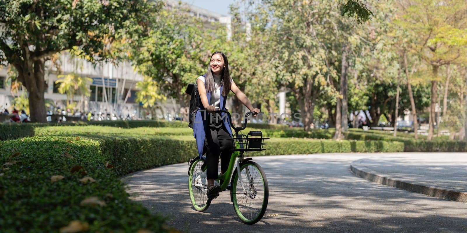 Asian businesswoman in bicycle go to work at office. Bike commuting, happy businesswoman using eco transport, Concept of eco lifestyle.
