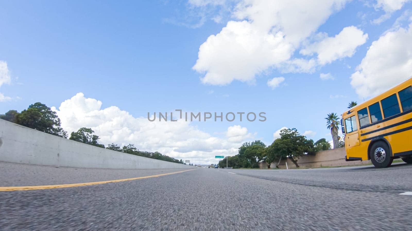 Santa Maria, California, USA-December 6, 2022-On a clear winter day, a car smoothly travels along Highway 101 near Santa Maria, California, under a brilliant blue sky, surrounded by a blend of greenery and golden hues.