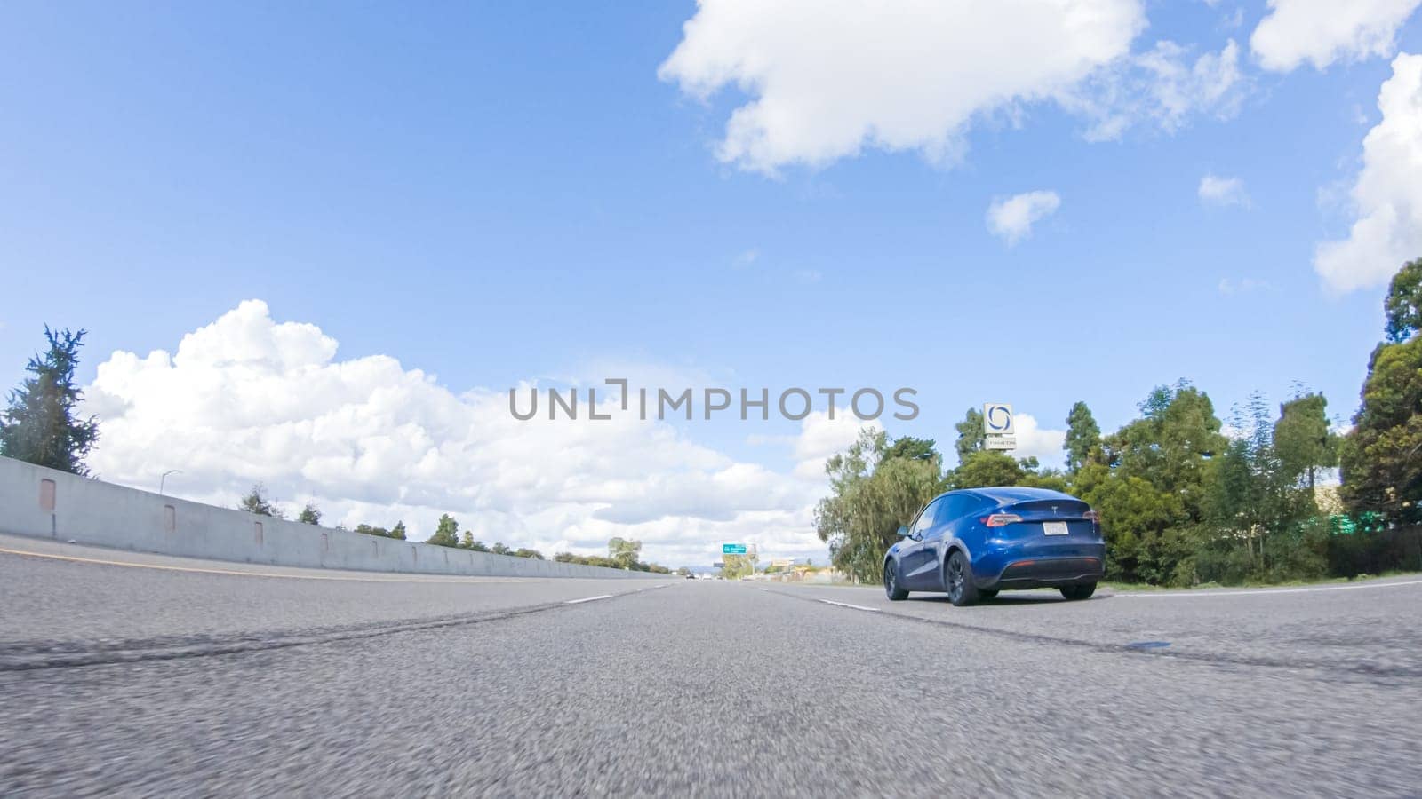 Santa Maria, California, USA-December 6, 2022-On a clear winter day, a car smoothly travels along Highway 101 near Santa Maria, California, under a brilliant blue sky, surrounded by a blend of greenery and golden hues.