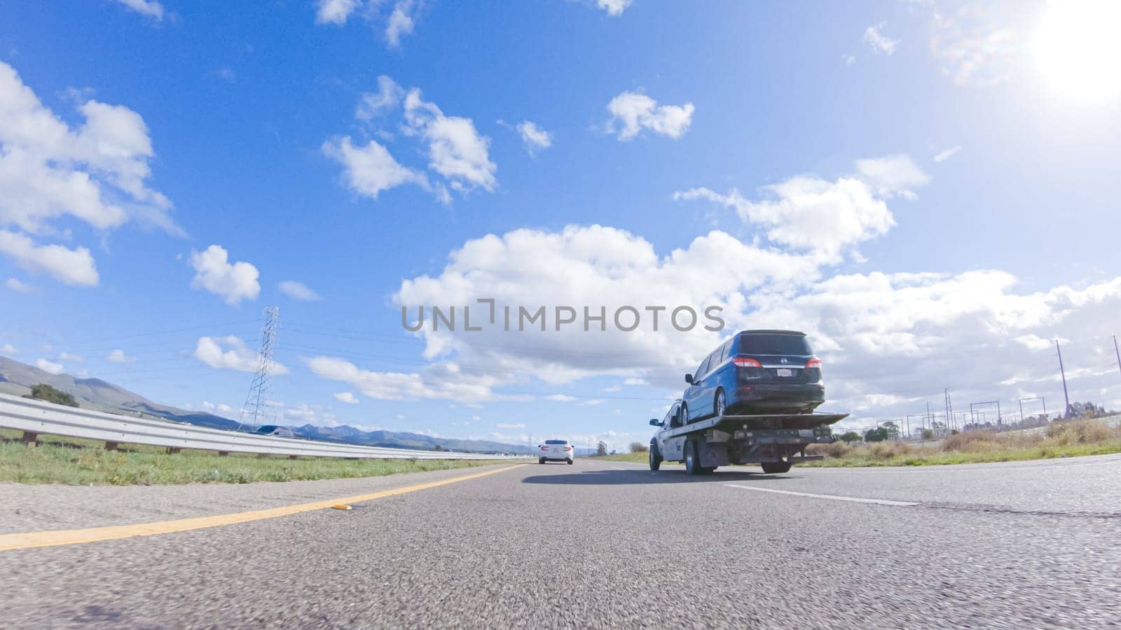 Santa Maria, California, USA-December 6, 2022-On a clear winter day, a car smoothly travels along Highway 101 near Santa Maria, California, under a brilliant blue sky, surrounded by a blend of greenery and golden hues.