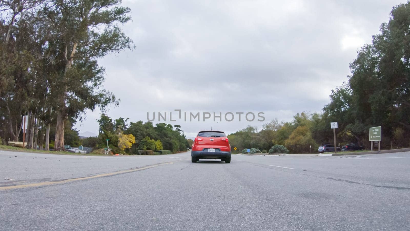 Santa Maria, California, USA-December 6, 2022-Vehicle navigates the streets of Morro Bay, California, during a cloudy winter day. The atmosphere is moody and serene as the overcast sky casts a soft light on the charming buildings and quiet streets of this coastal town.