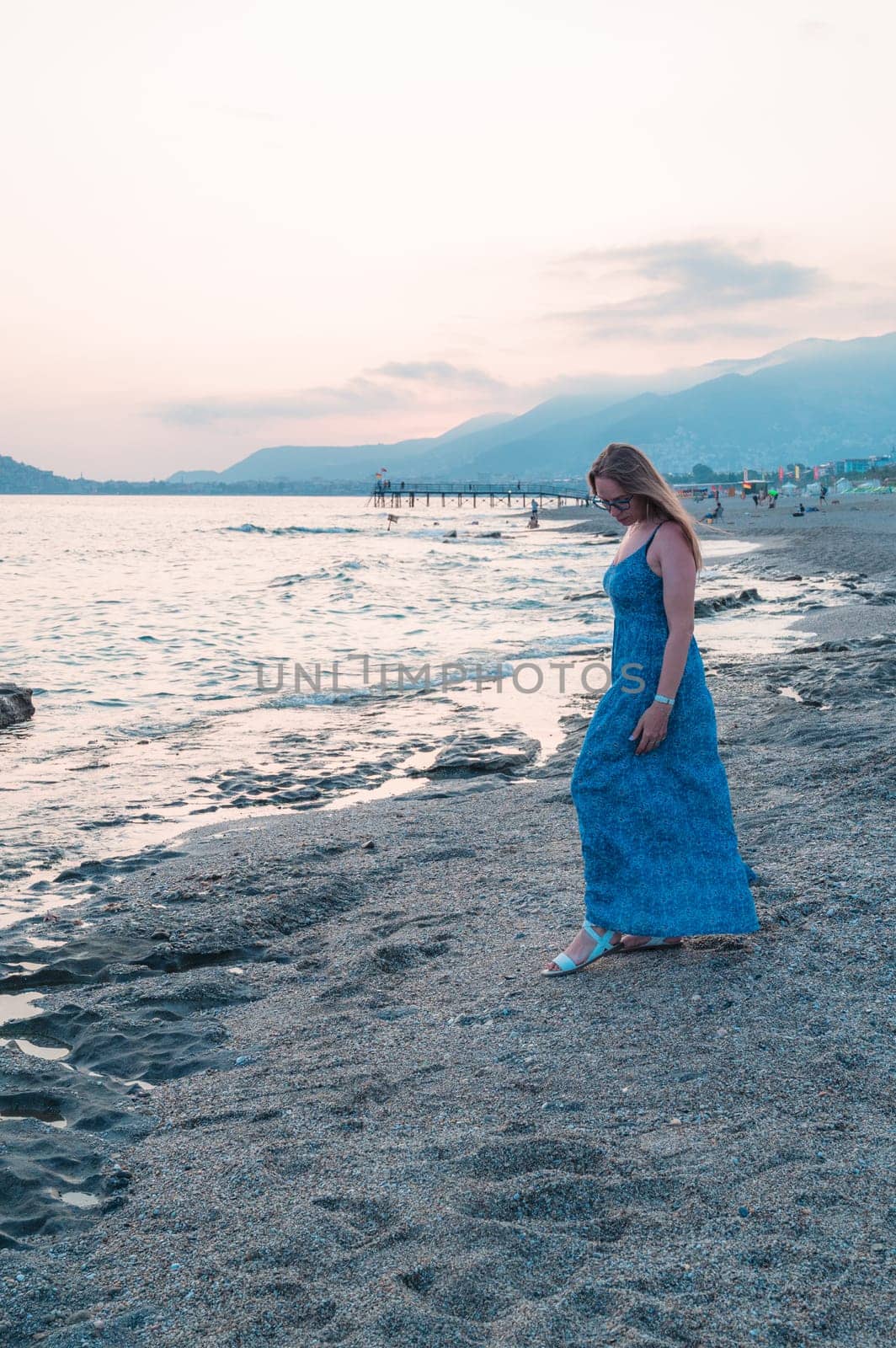 Woman sits on the beach and looks at the sea in Alanya city, Turkey. Travelling or vacation concept