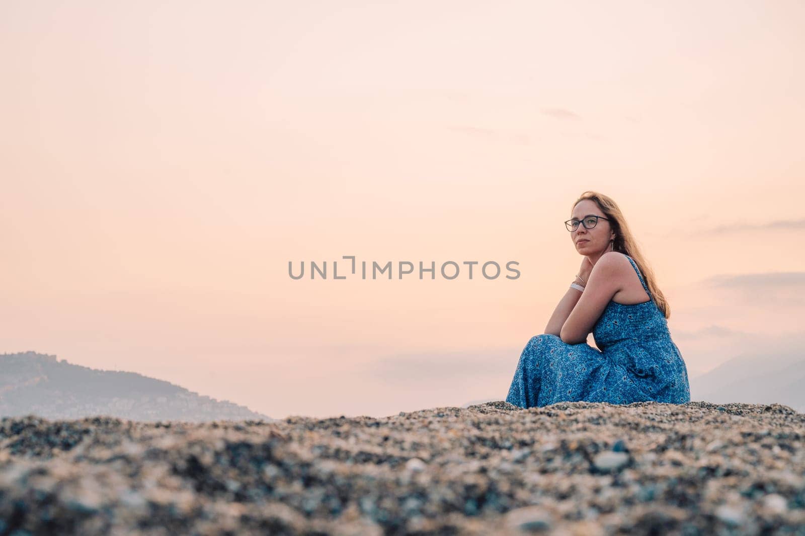 Woman sits on the beach and looks at the sea in Alanya city, Turkey. Travelling or vacation concept