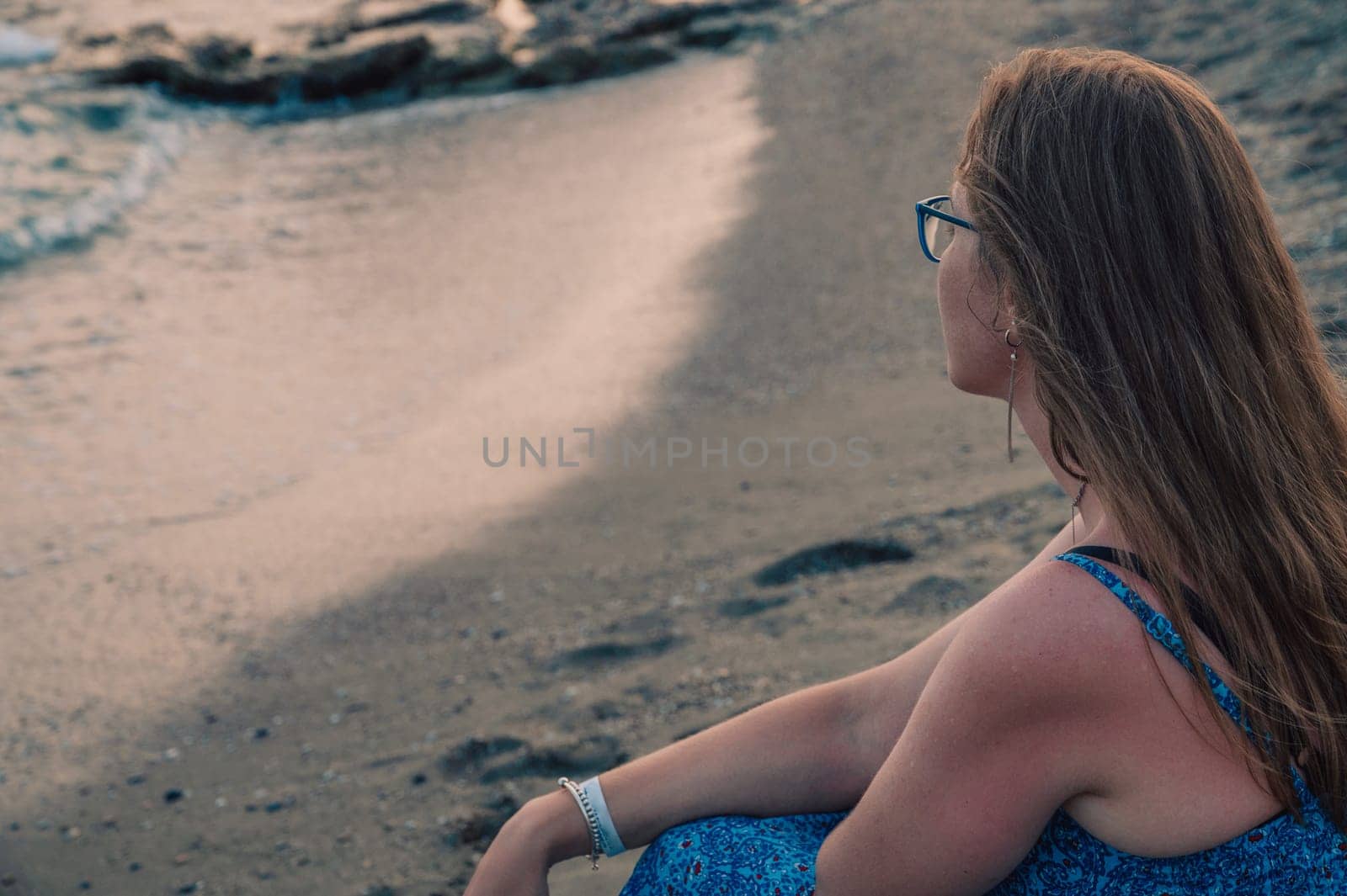 Woman sits on the beach and looks at the sea in Alanya city, Turkey. Travelling or vacation concept