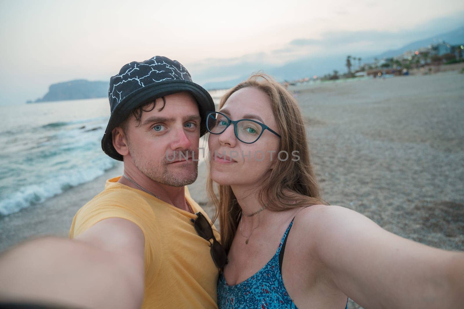 Happy couple taking a photo on a beach by rusak